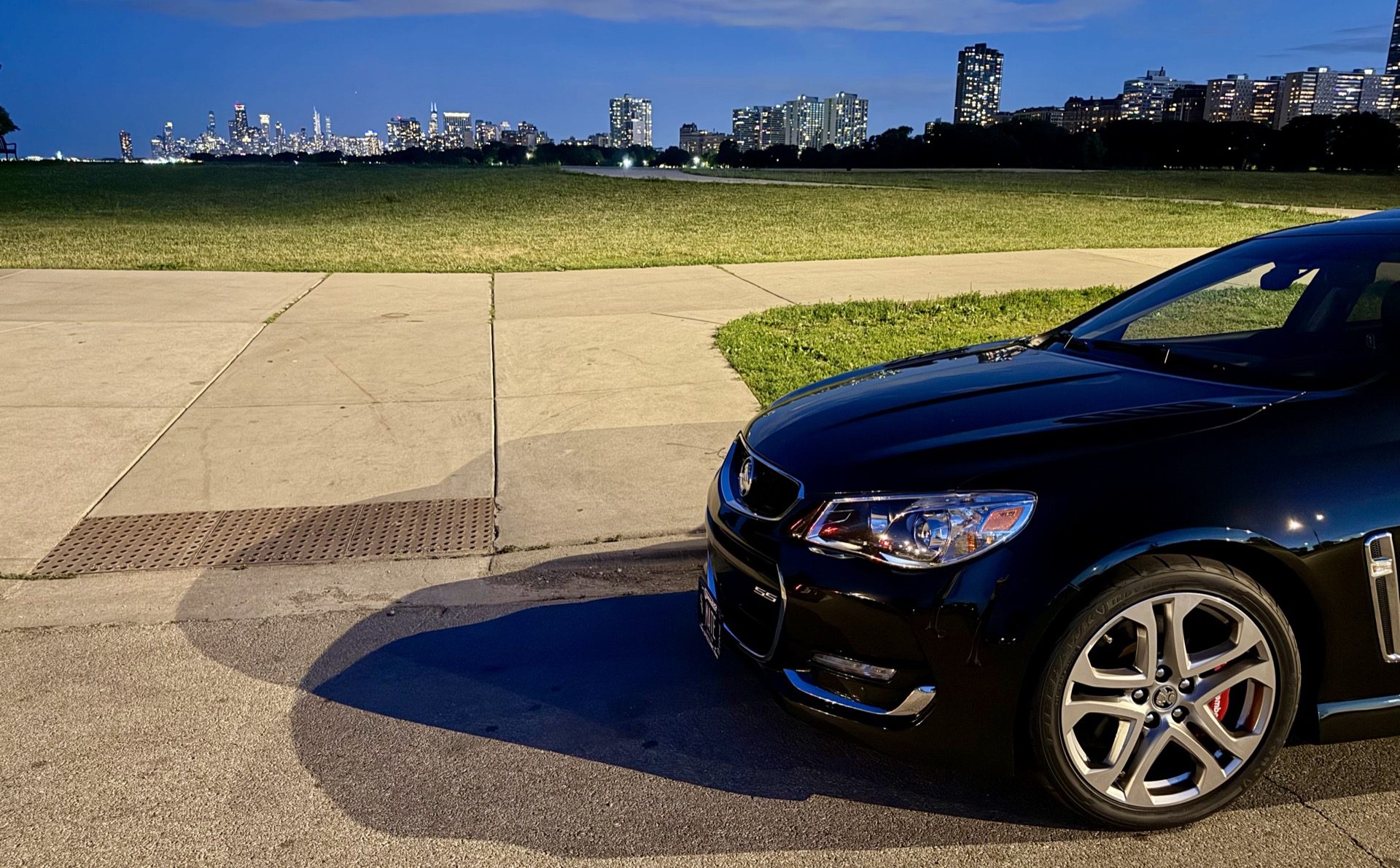 Low angle close-up of the front of the Chevy SS with the Chicago skyline across the harbor in the background